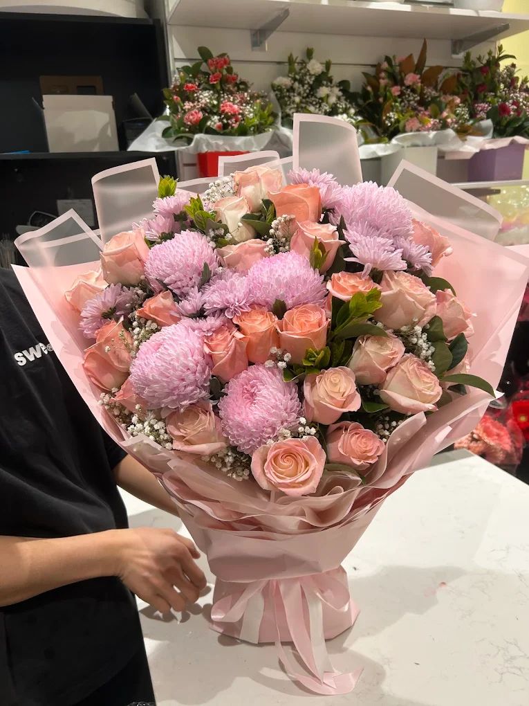 Pink roses and chrysanthemums wrapped in blush paper
