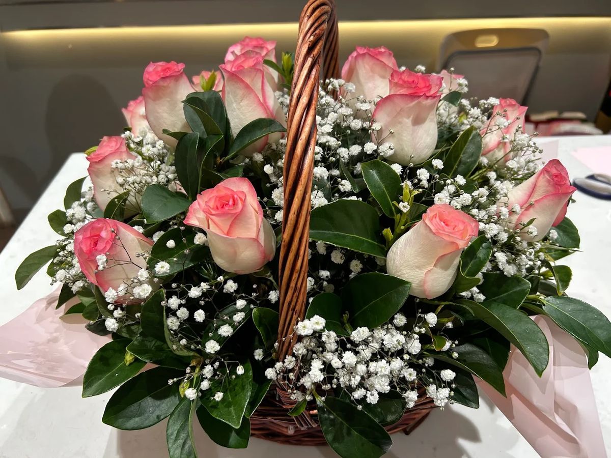 Basket of pink and white roses with baby's breath